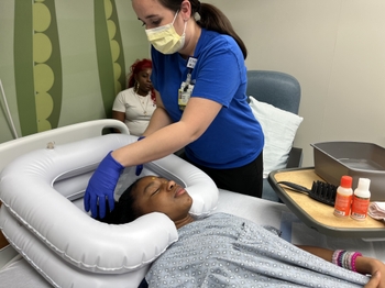 Nurse washing patient's hair