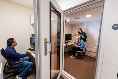 Photo of eeg booth with a test subject and two technicians