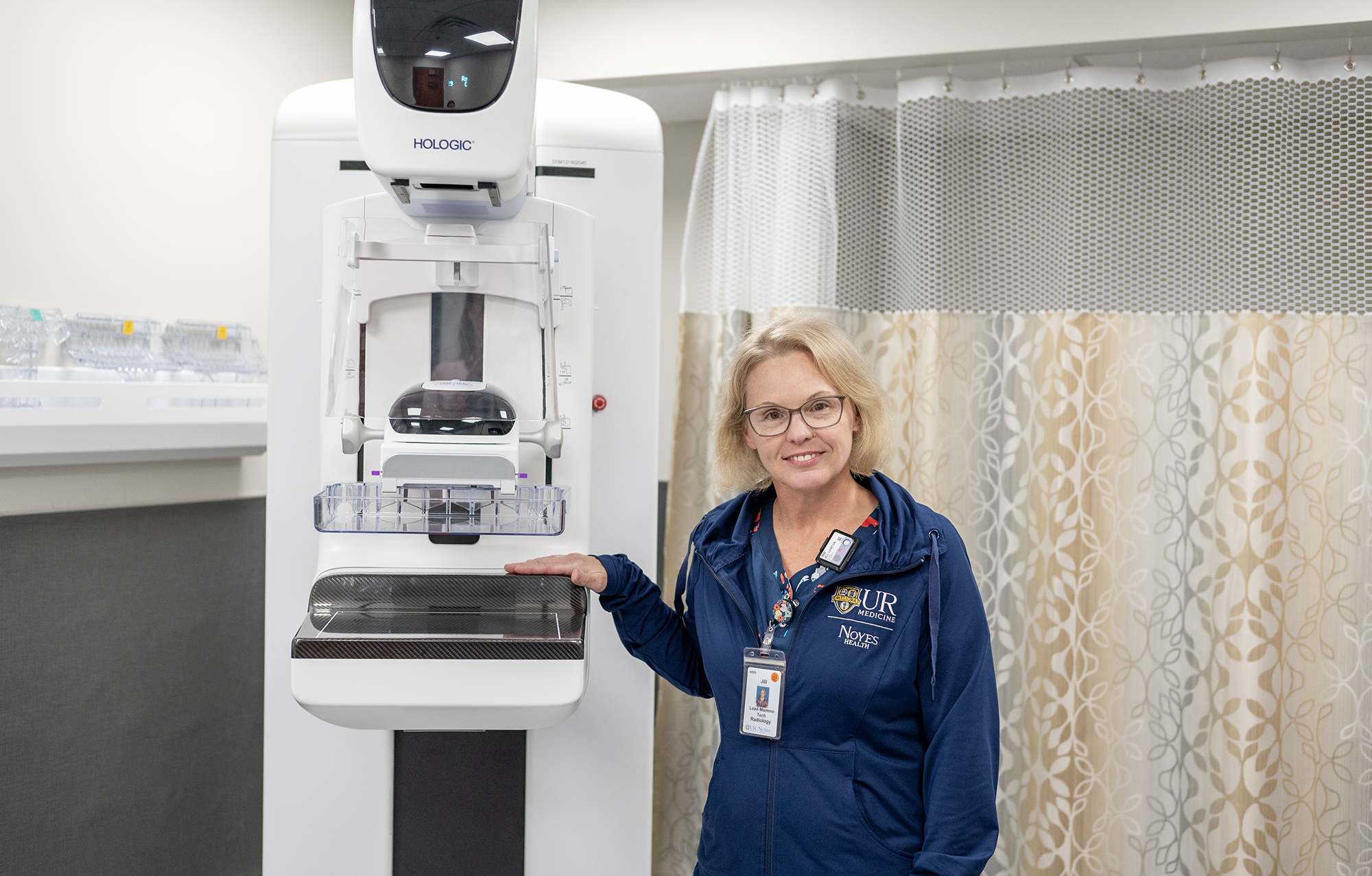 Jill Lawton poses for a photo with the new mammogram machine in Geneseo.
